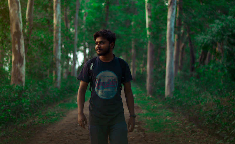 homme en t-shirt bleu col rond debout en forêt