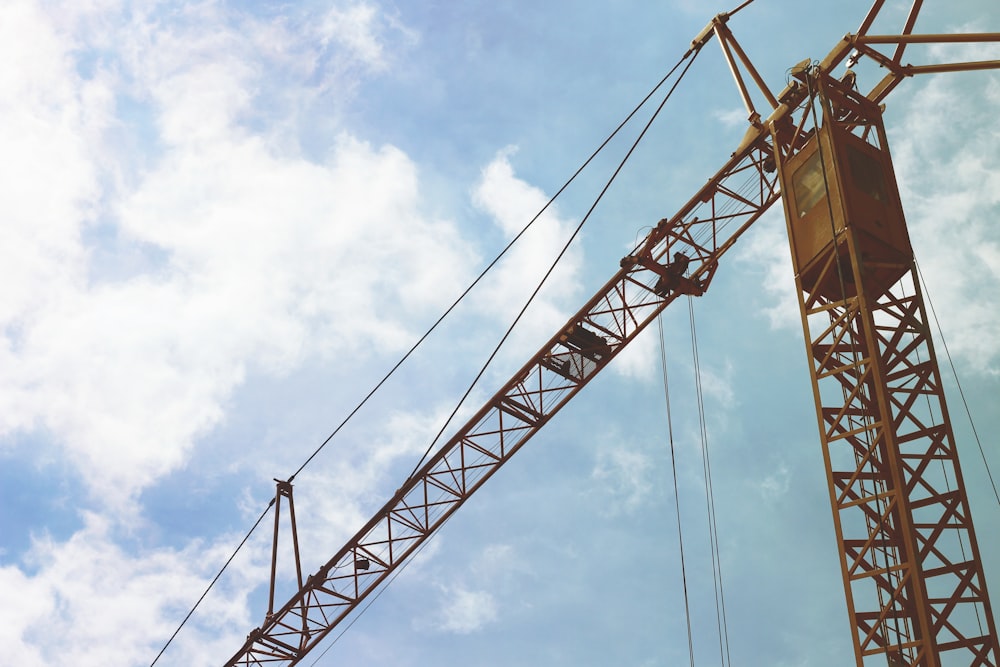 orange crane under cloudy sky during daytime