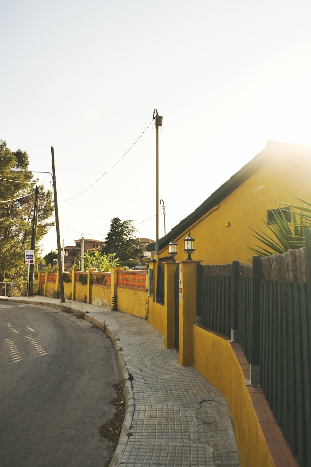 yellow and brown wooden fence near road