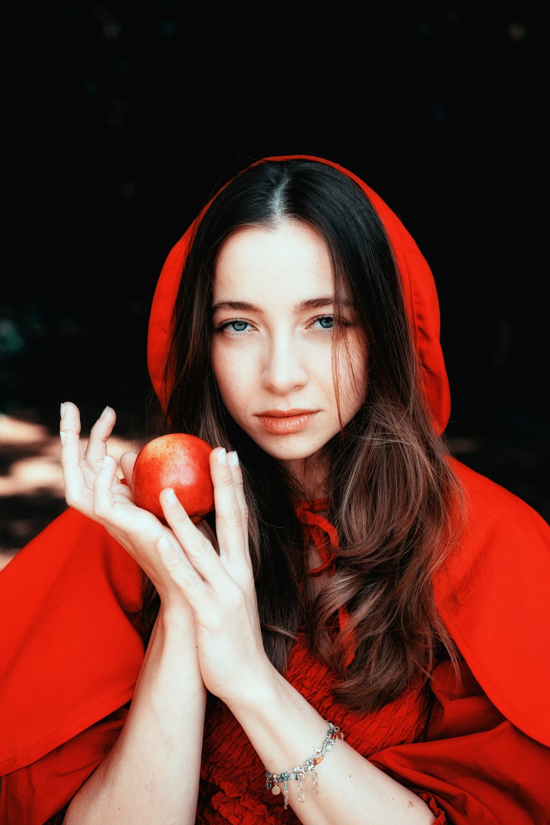 woman in orange hijab holding red apple