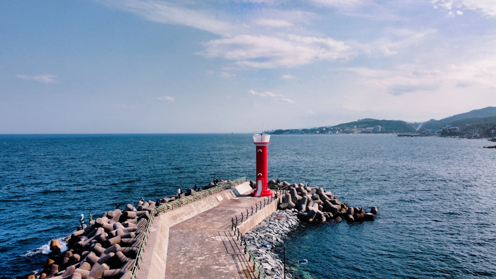 red and white lighthouse near body of water during daytime