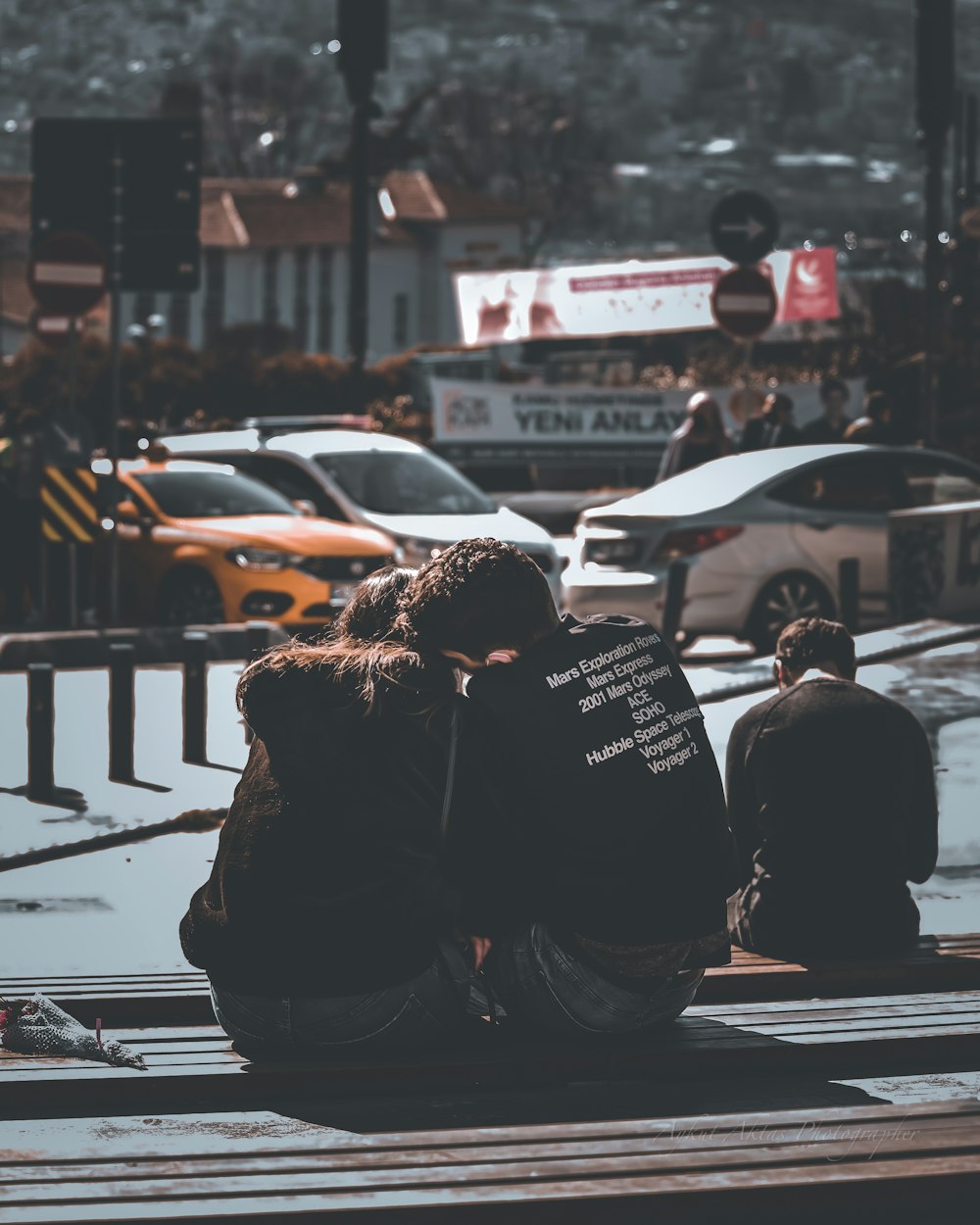 man and woman sitting on sidewalk during daytime