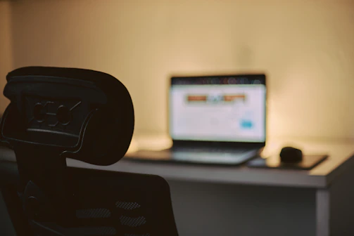 Monitor de computador preto com tela plana sobre mesa preta