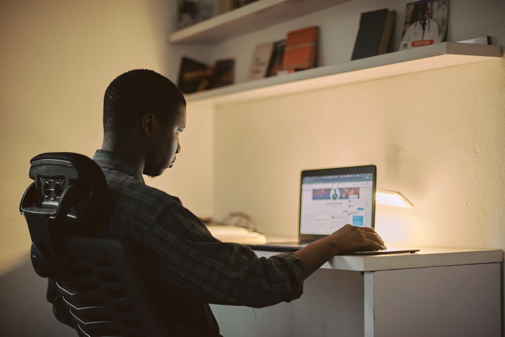 Hombre con camisa negra de manga larga usando MacBook Pro