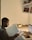 A student studying in a cozy library with books and a laptop.