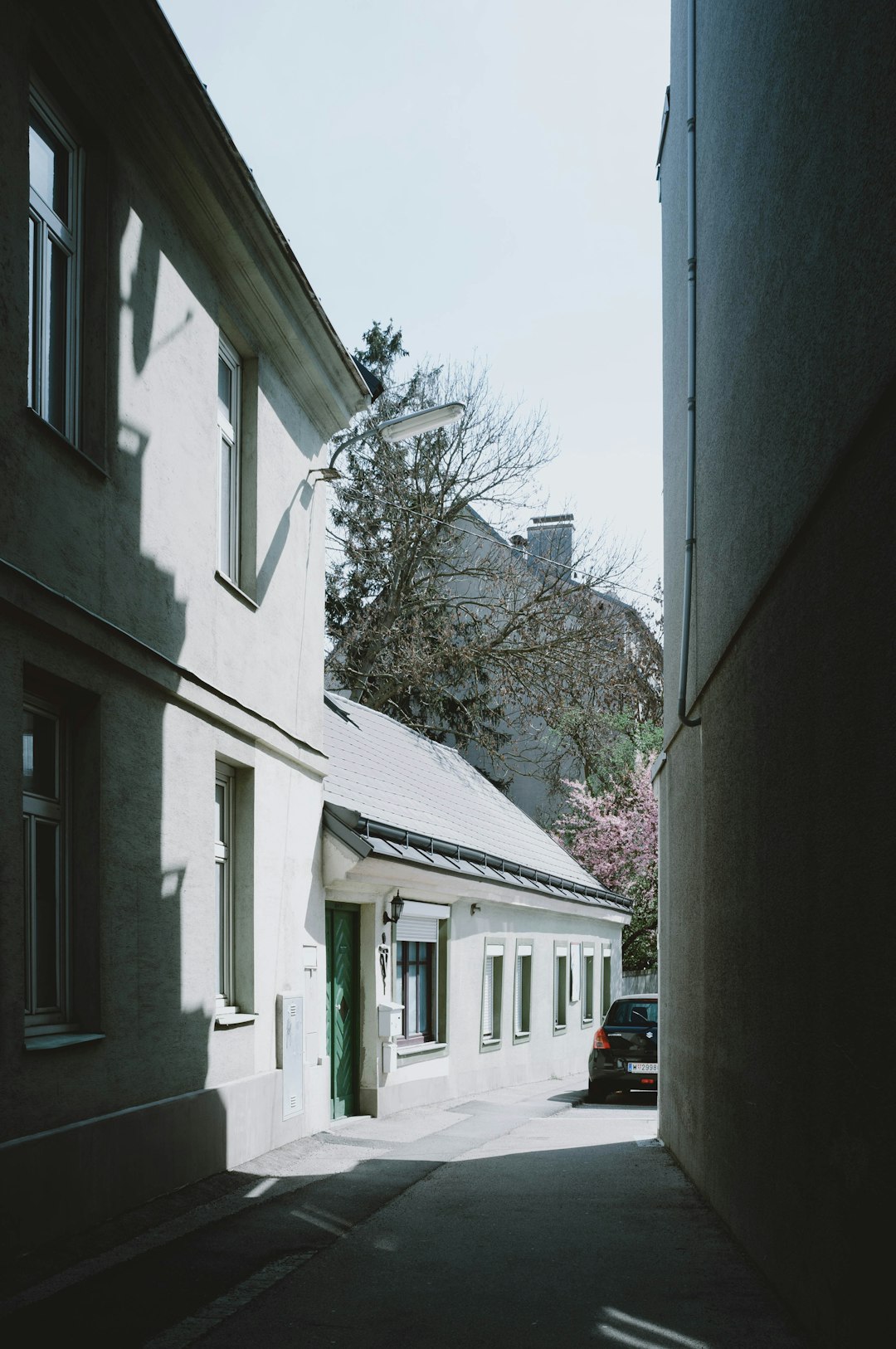 black car parked beside white concrete building during daytime