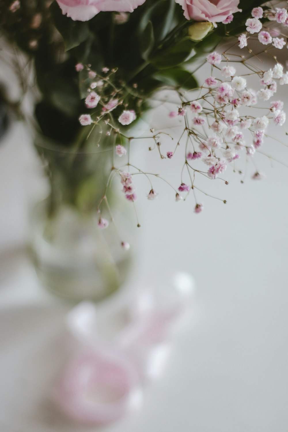 fiori bianchi e rosa in vaso di vetro trasparente