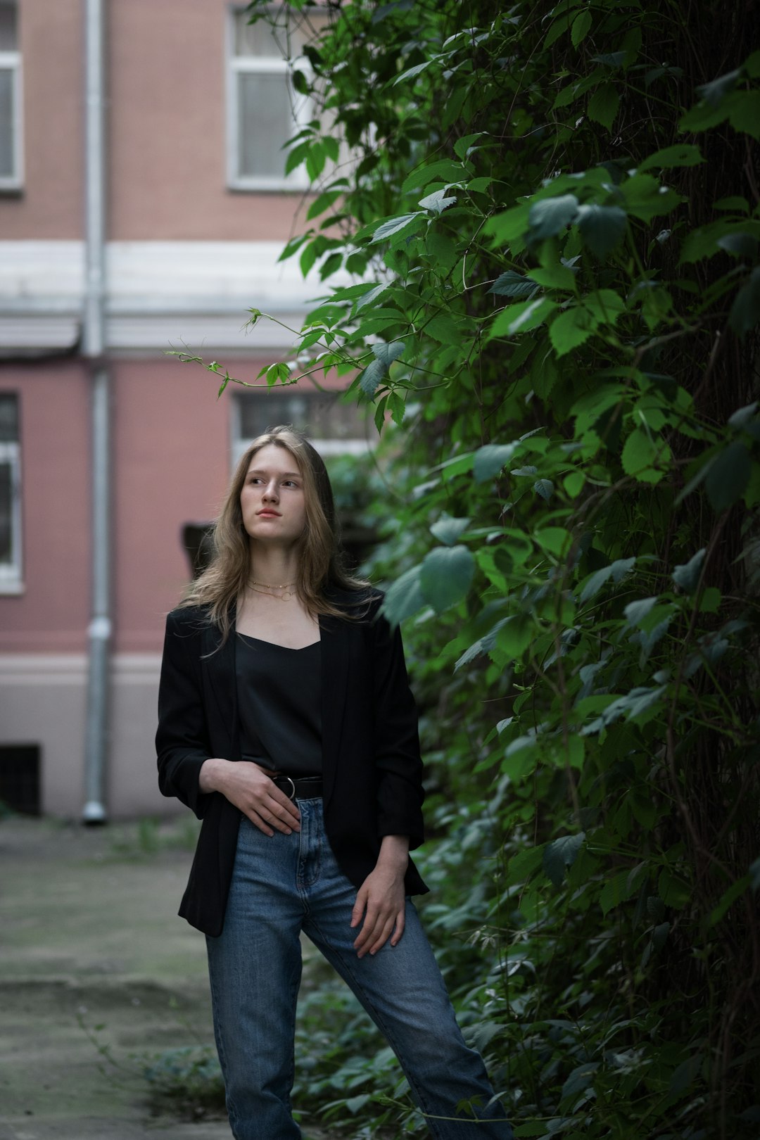 woman in black long sleeve shirt standing beside green plant during daytime