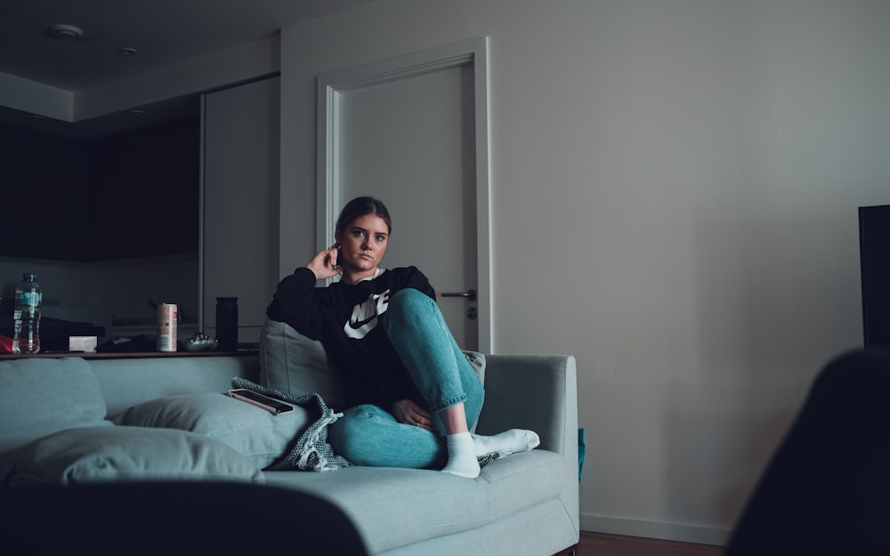 woman in black long sleeve shirt sitting on gray couch