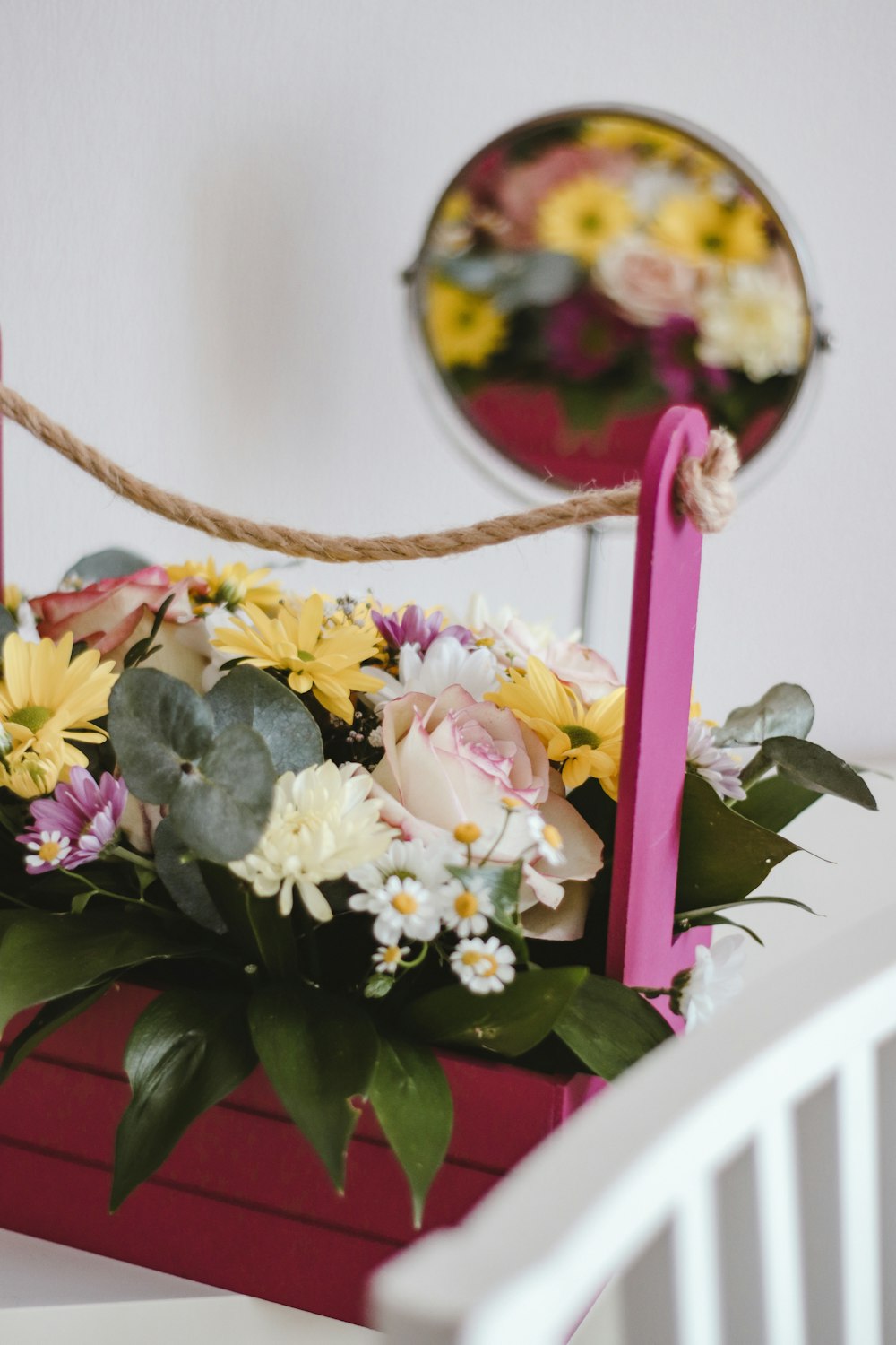 flores brancas e roxas na cesta suspensa de madeira marrom
