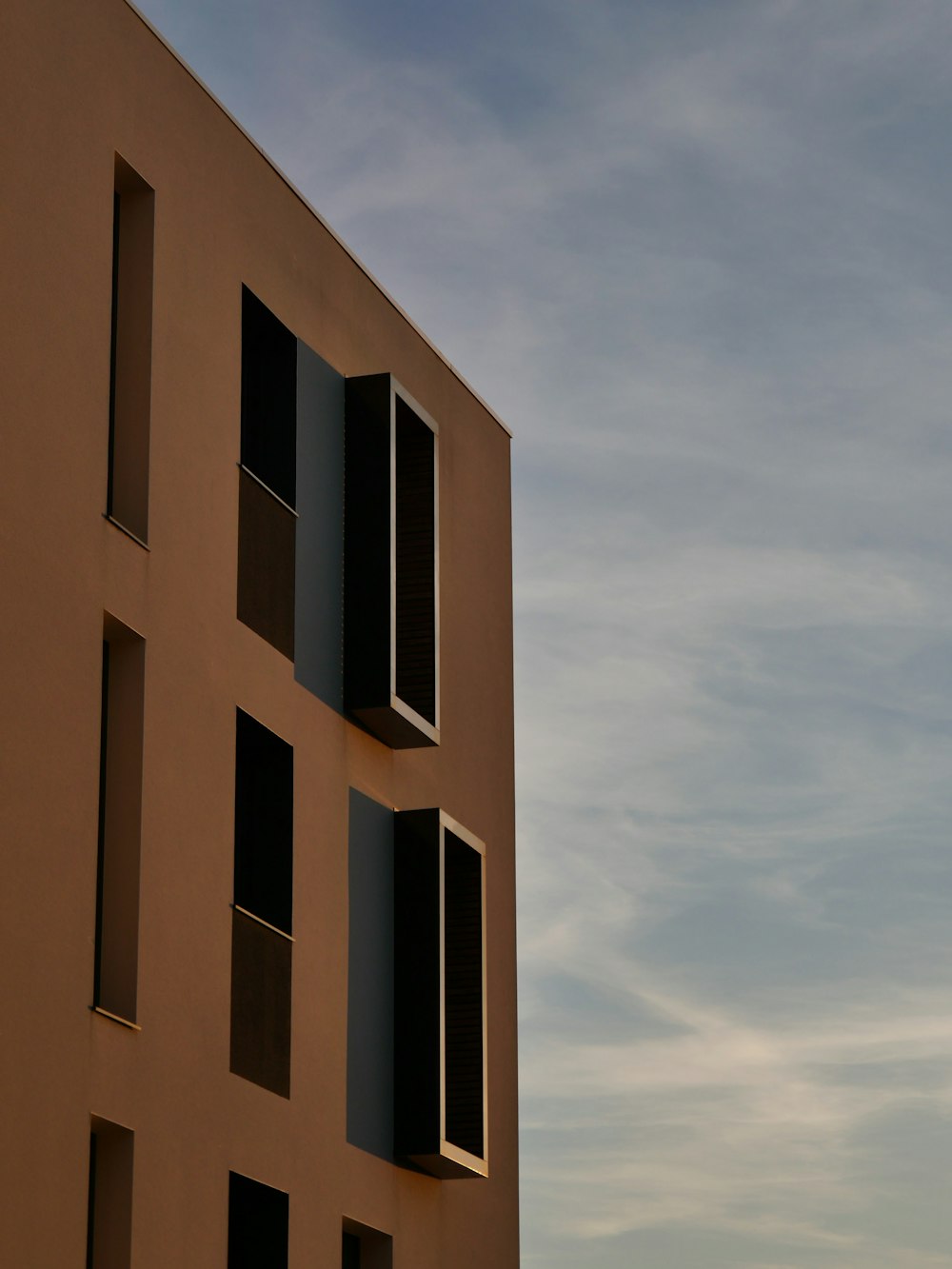 edificio in cemento marrone sotto nuvole bianche durante il giorno