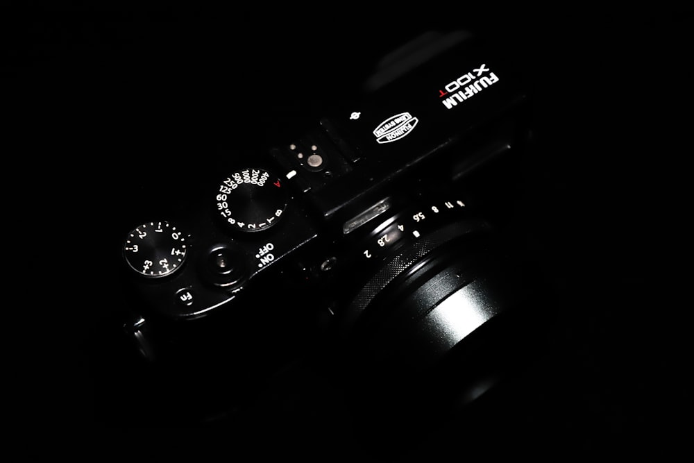 black nikon dslr camera on black surface