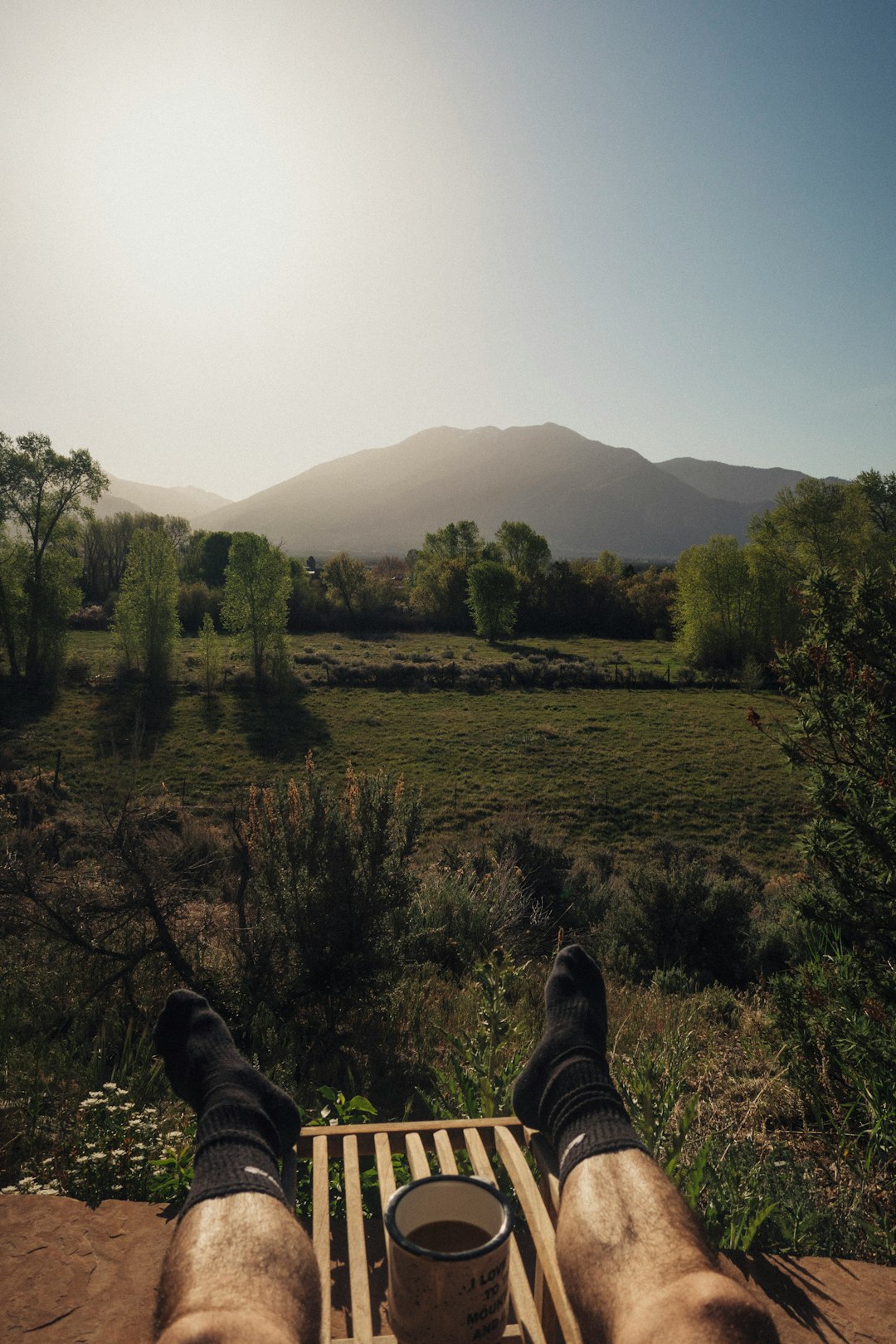 person in black pants lying on green grass field during daytime