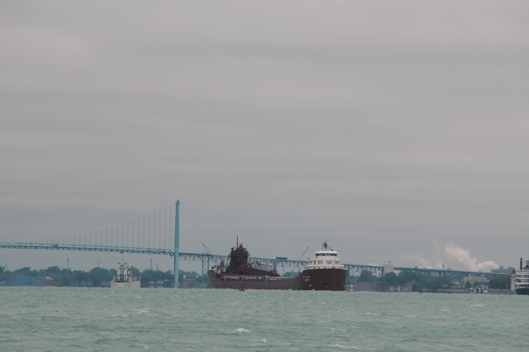 brown ship on sea under bridge during daytime