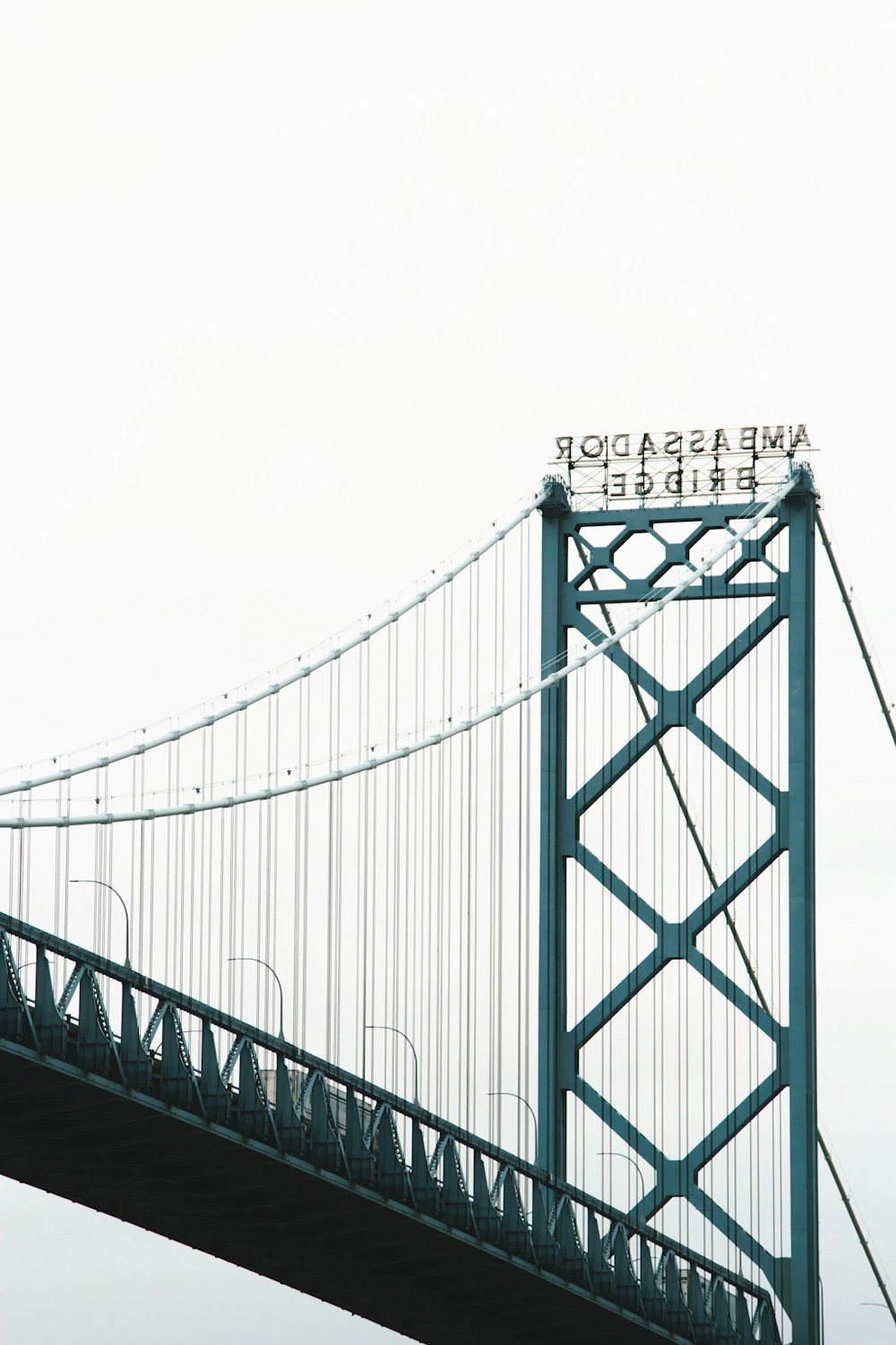 grayscale photo of bridge under cloudy sky