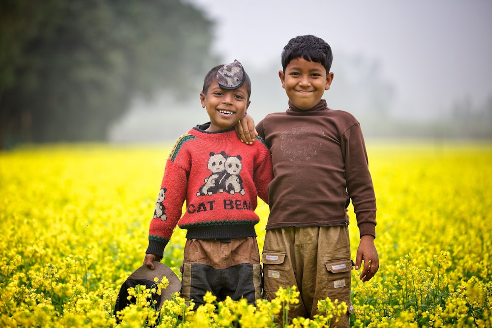 man in brown sweater holding woman in red sweater on yellow flower field during daytime