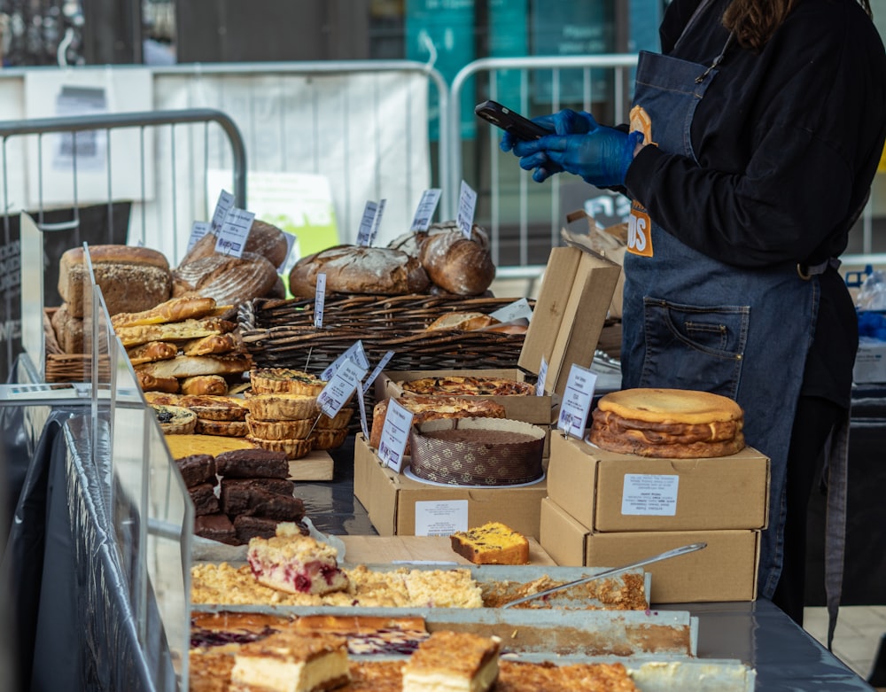 man in blue jacket standing in front of food display