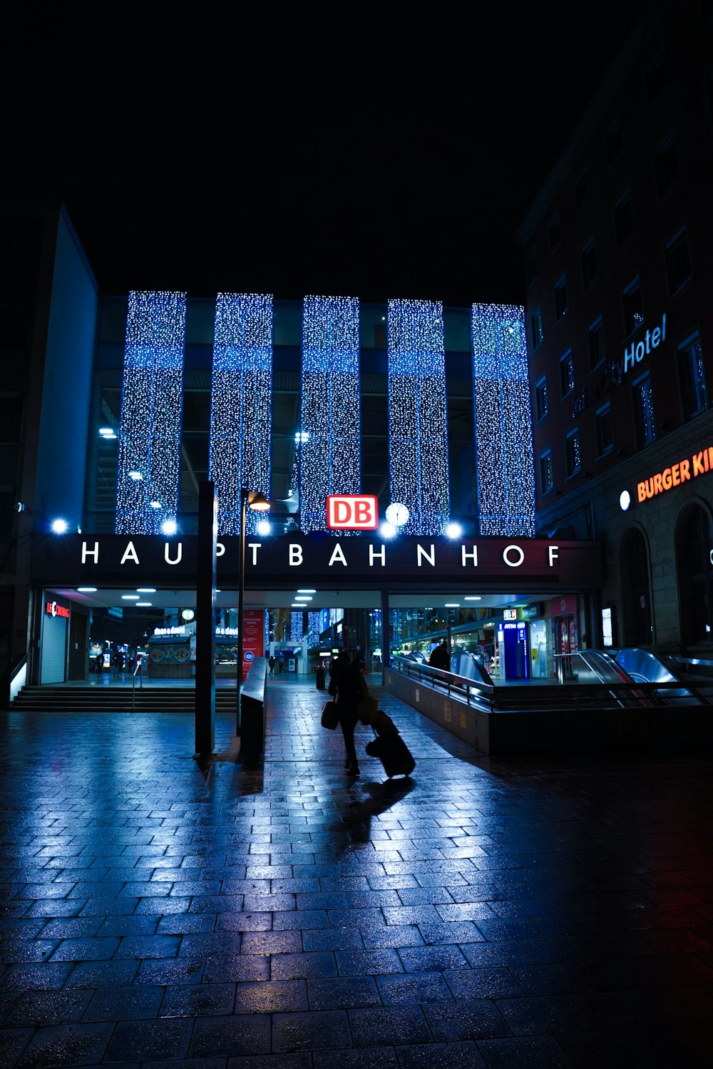 people walking on sidewalk near building during night time