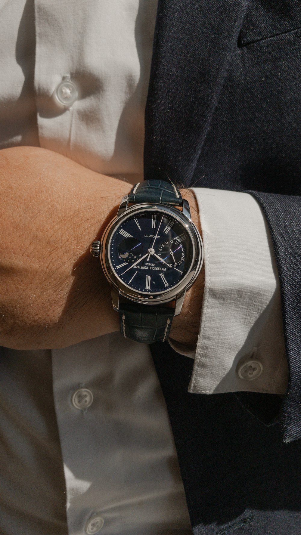 person wearing silver and black round analog watch
