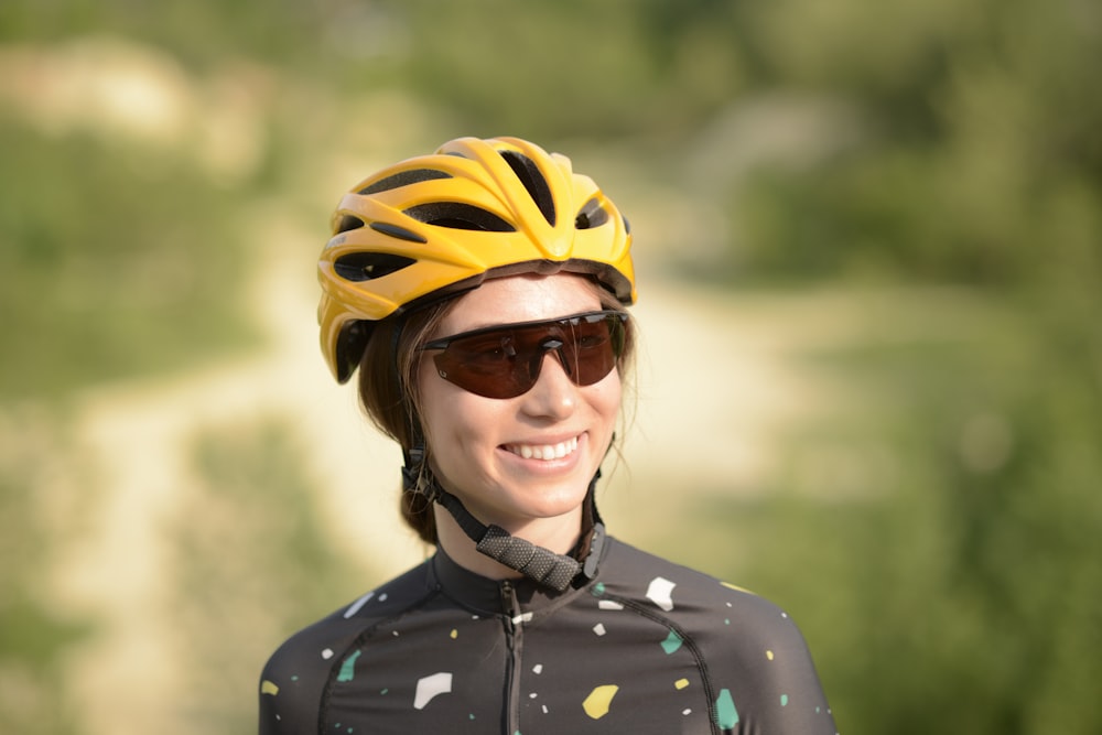 Frau in schwarz-weißem Polka Dot Button Up Shirt mit gelbem Fahrradhelm