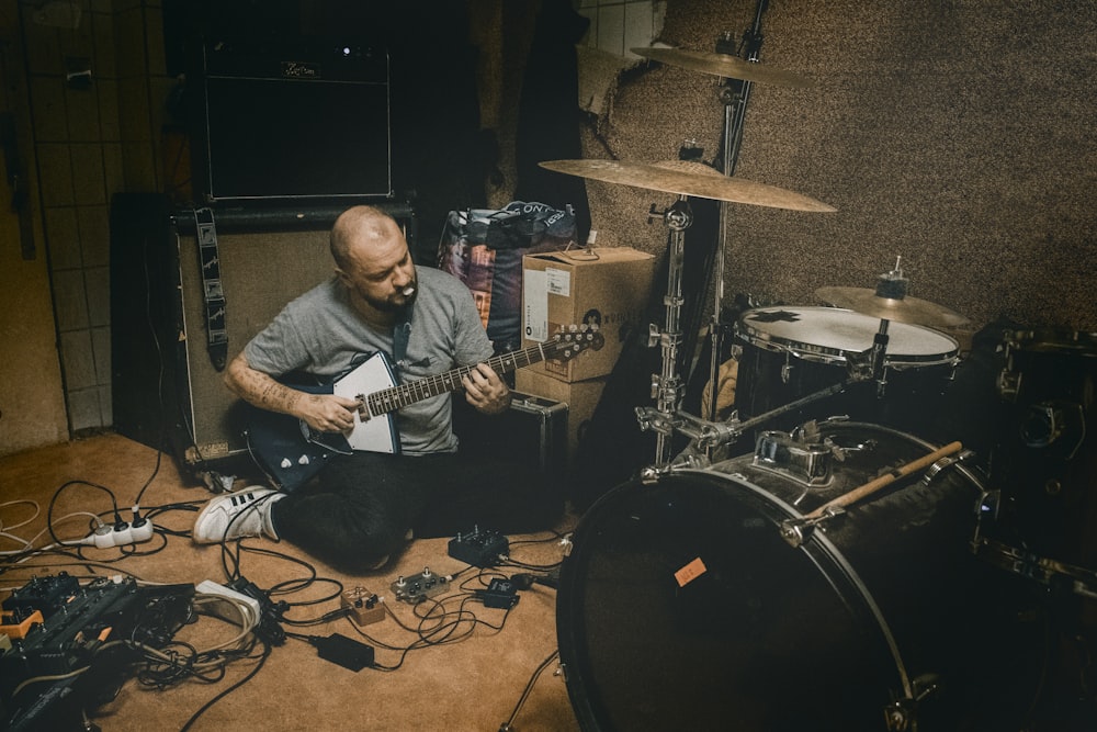 man in black crew neck t-shirt playing black and white electric guitar