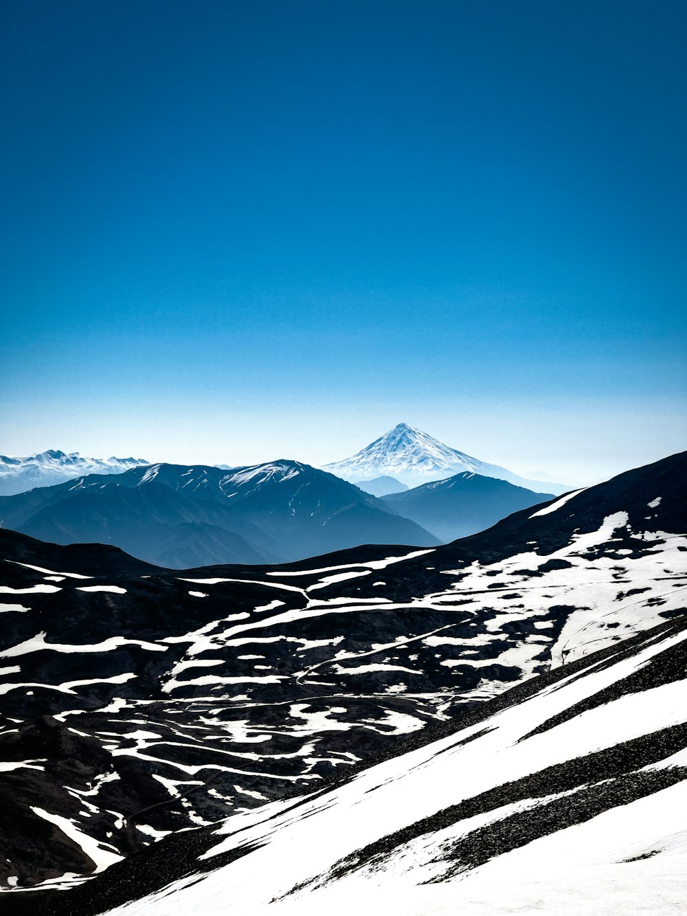 montanha coberta de neve sob o céu azul durante o dia