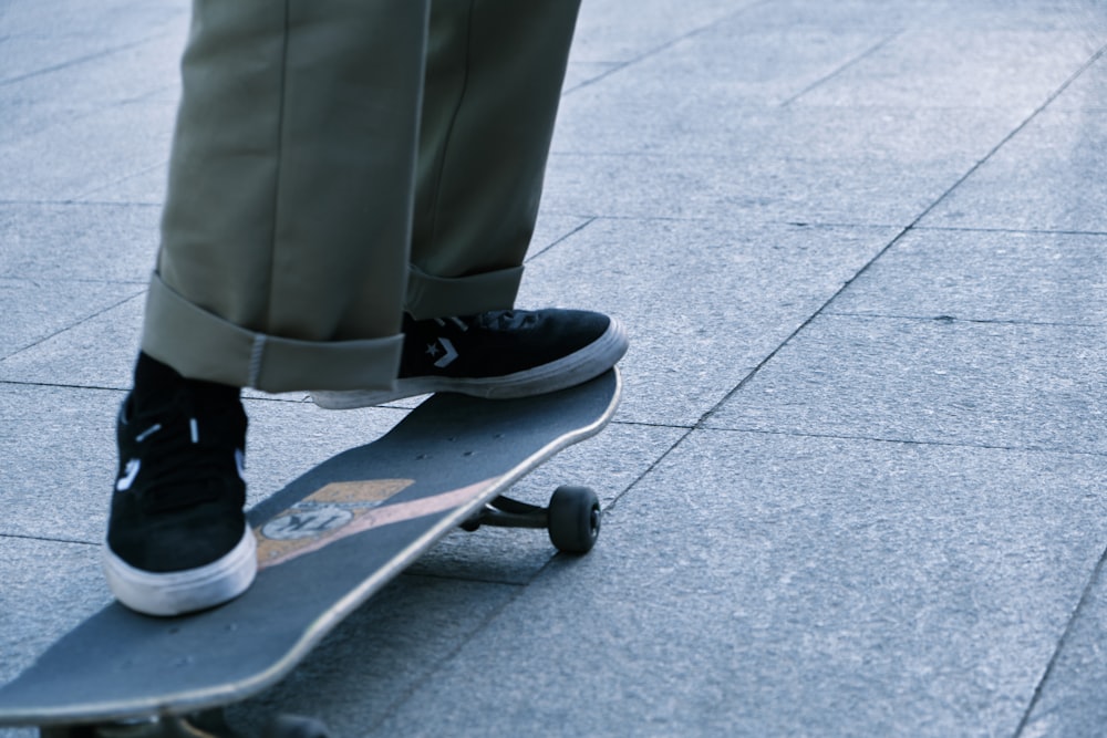 person in gray pants and black and white nike sneakers