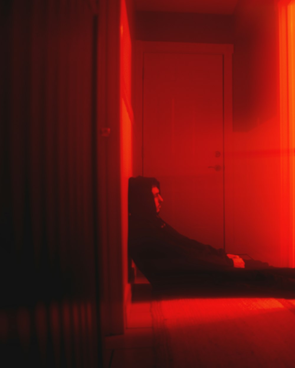 person lying on bed near white wooden door