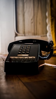 black telephone on brown wooden table