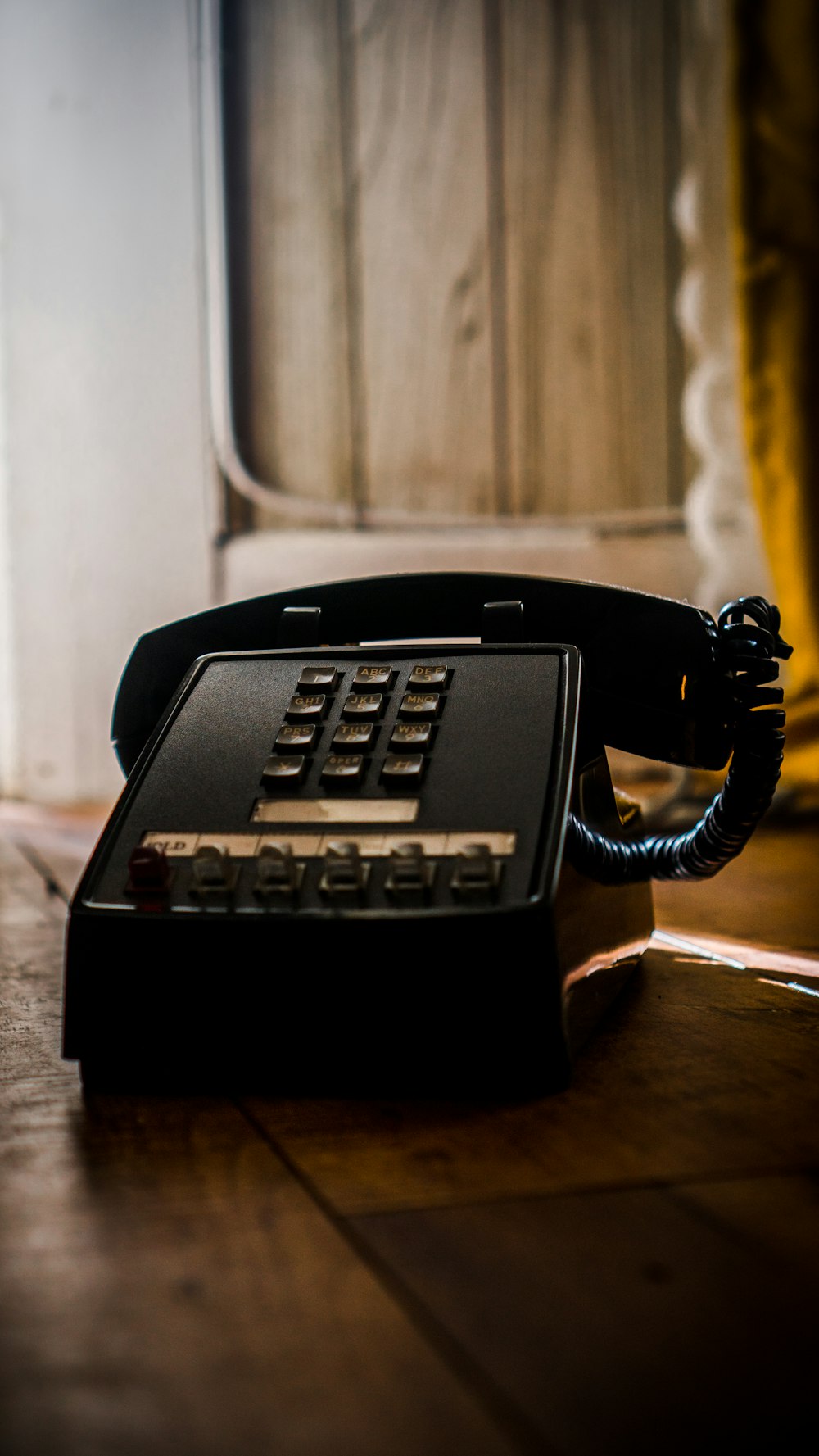 schwarzes Telefon auf braunem Holztisch