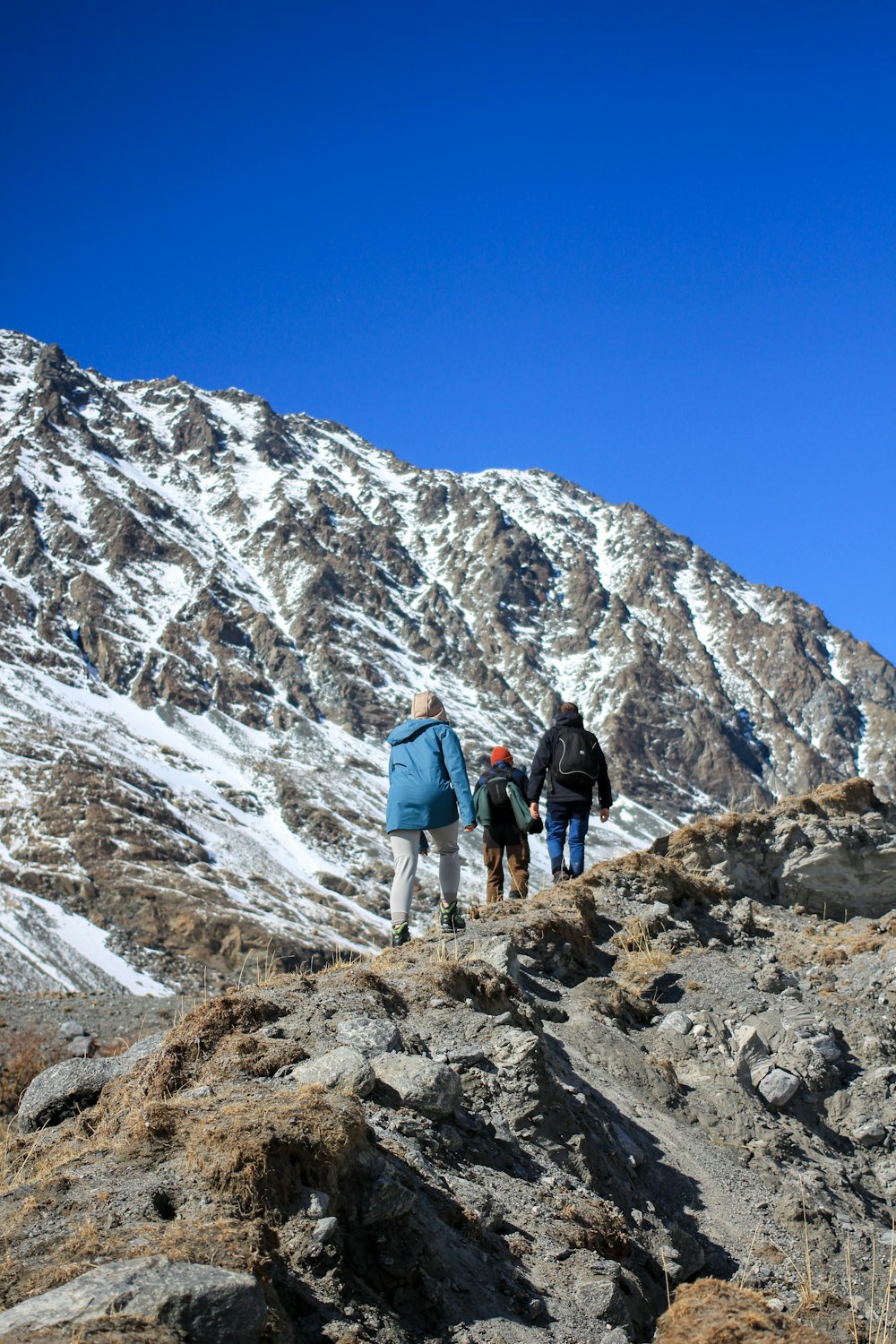 2 men hiking on rocky mountain during daytime
