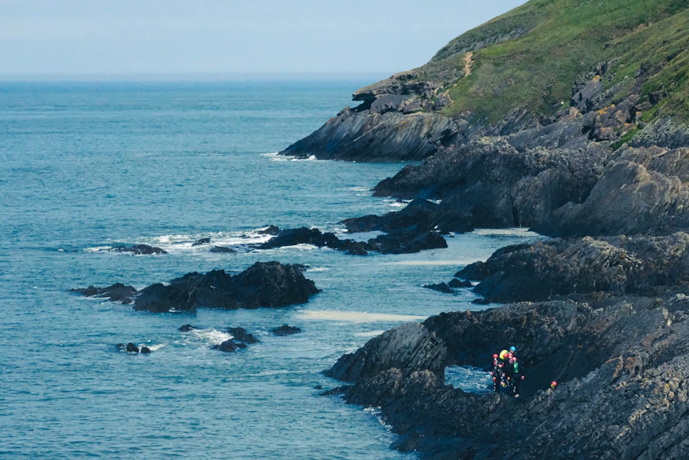 person standing on rock formation near sea during daytime