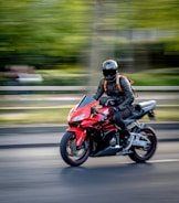 man in black helmet riding red sports bike