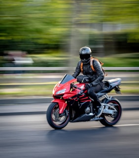 man in black helmet riding red sports bike