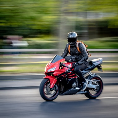 man in black helmet riding red sports bike