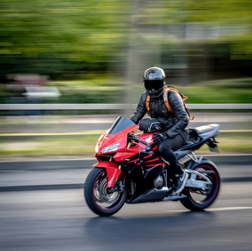 man in black helmet riding red sports bike
