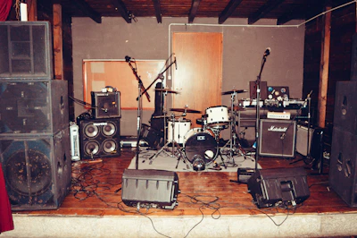 Volunteers setting up a small stage for a folk music event in a community hall.