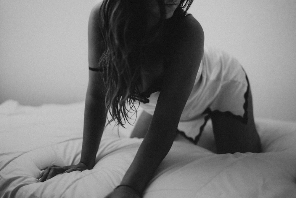 mujer en camiseta sin mangas acostada en la cama