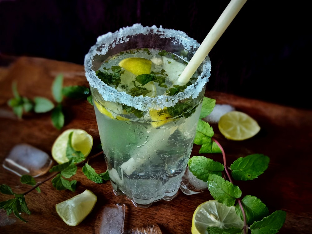 klares Trinkglas mit Eiswürfeln und grünen Blättern