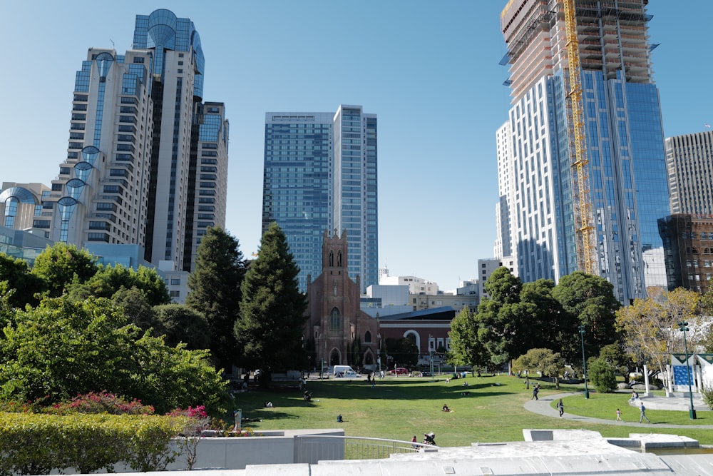 green grass field near high rise buildings during daytime