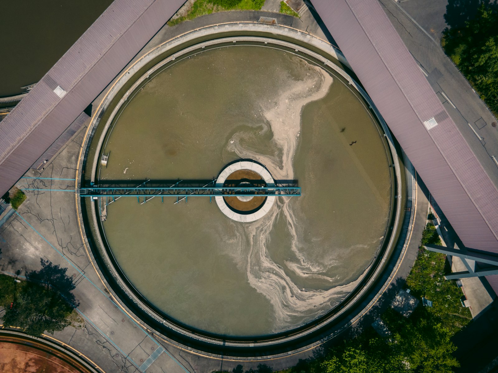 Aerial view of circular sewage treatment tanks at a wastewater treatment plant.
