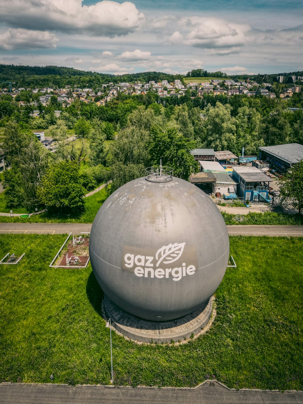 white and gray round water tank on green grass field during daytime