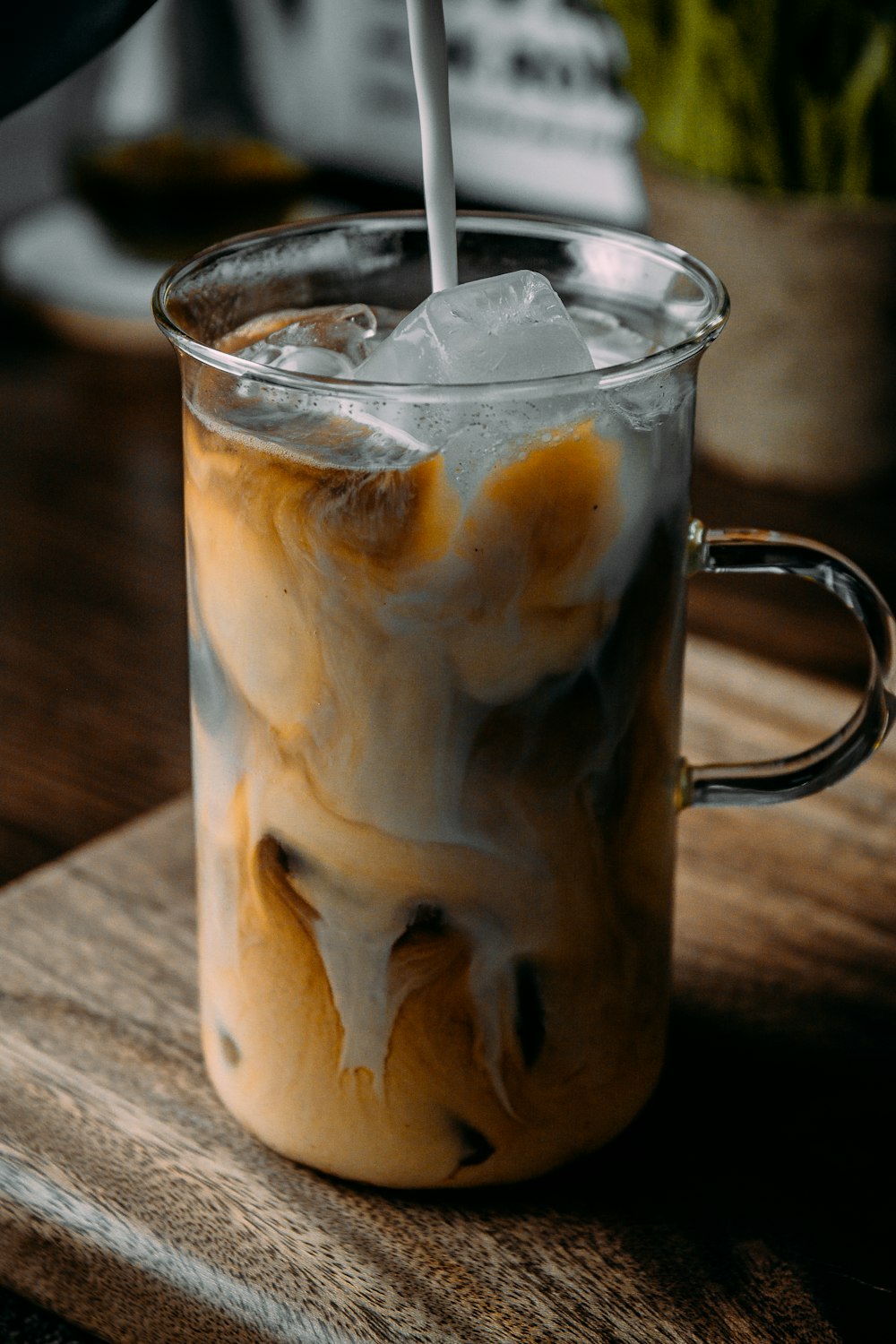 clear drinking glass with ice and white liquid