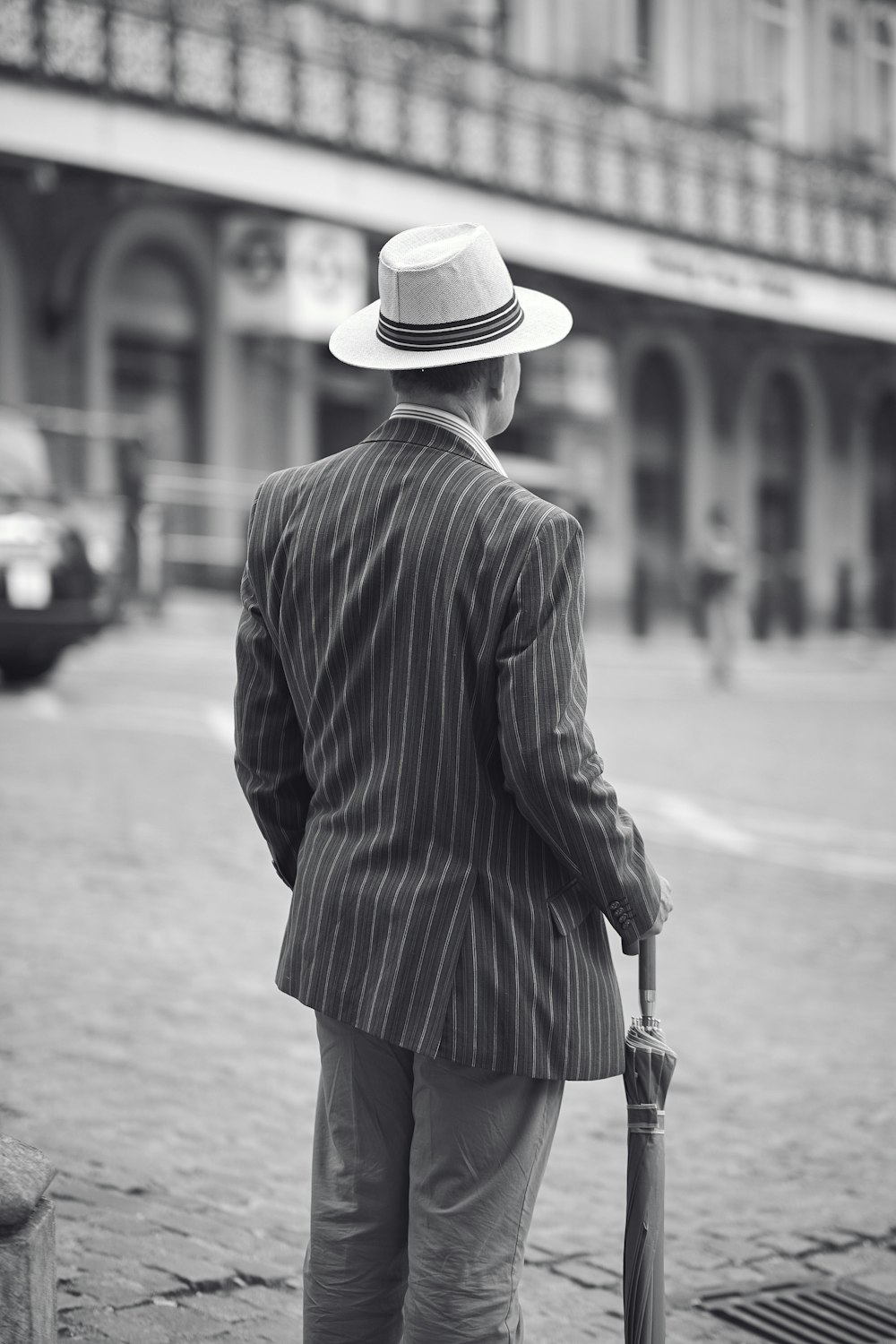 grayscale photo of woman in black coat and black skirt walking on sidewalk