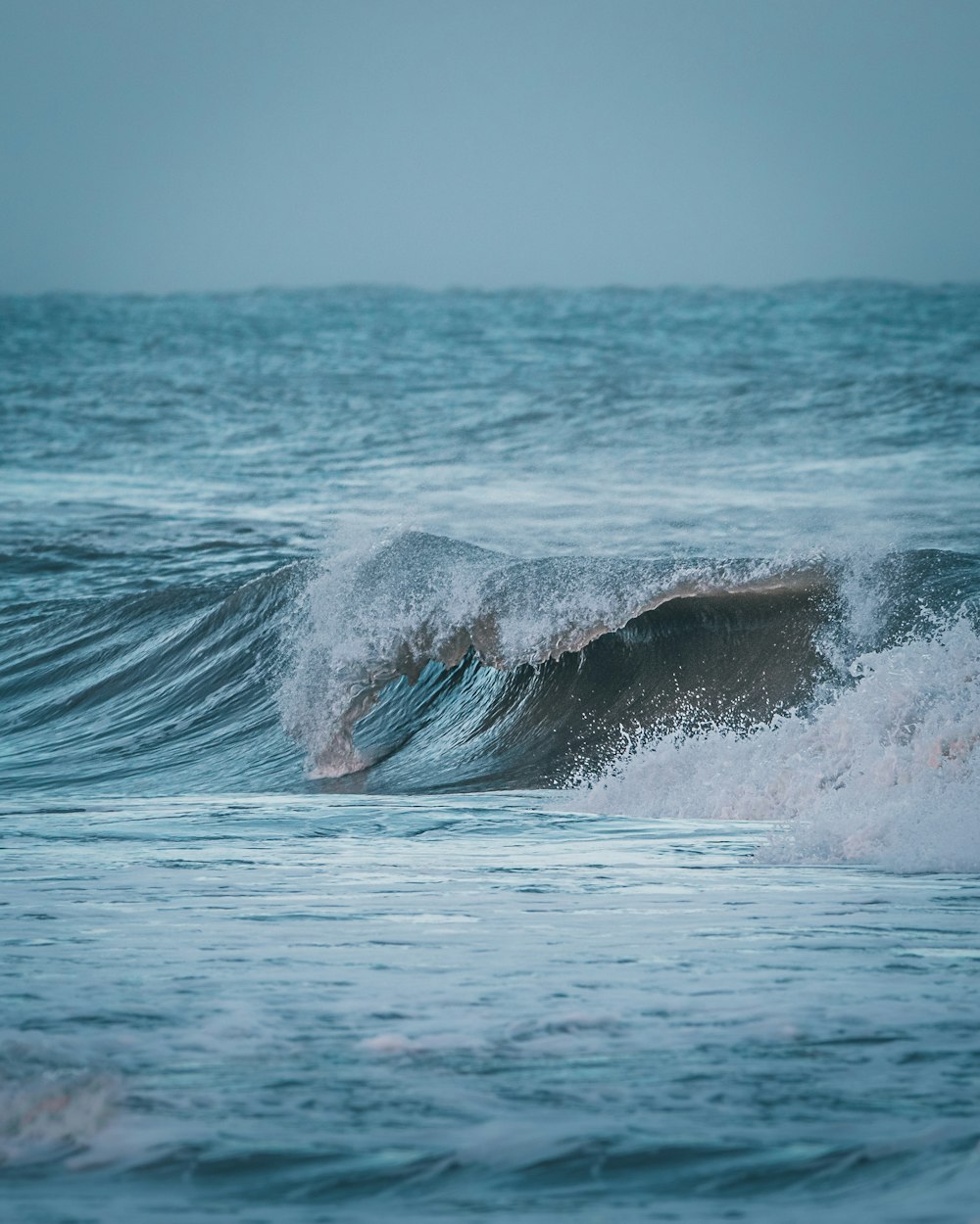 sea waves crashing on shore during daytime