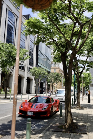 A vibrant city street scene showcasing a sleek Cars Cherry vehicle parked with stylish urban buildings in the background.