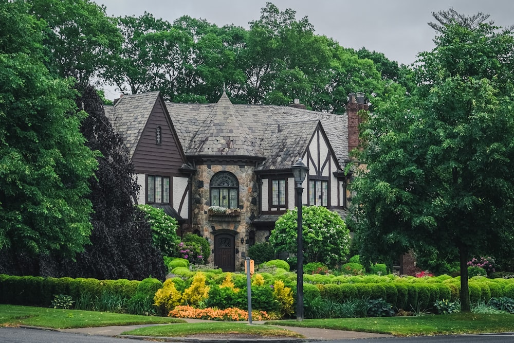 brown and gray concrete house surrounded by green trees during daytime