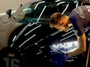 man in blue crew neck t-shirt standing beside black car