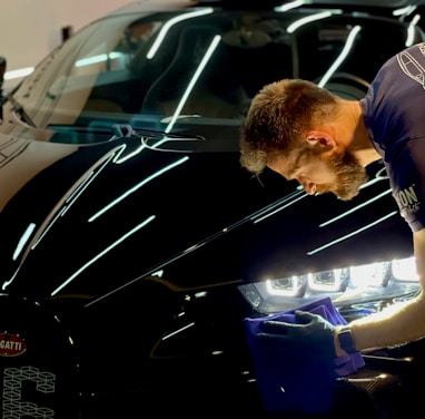 man in blue crew neck t-shirt standing beside black car