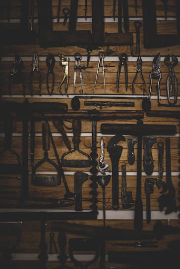 A close-up of vintage car parts and restoration tools neatly arranged on a wooden workbench.